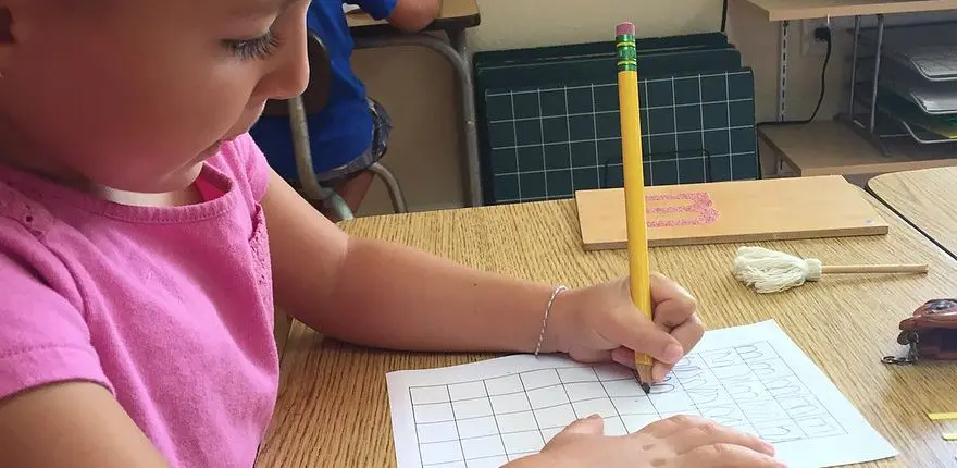 e63aae_64de42aca84c482388c80b0dd61e7710 a child counting Montessori beads, building early math skills