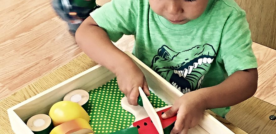 e63aae_7b160d57e0404ed899790d01aa3f9398 a child constructing geometric figures with Montessori constructive triangles