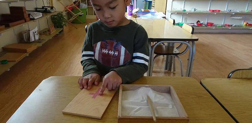 e63aae_b0e078dc6d4847a1a5a5df8aa3fa2a35 students exploring geography through Montessori puzzle maps