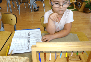 a child exploring size gradation with Montessori pink tower materials