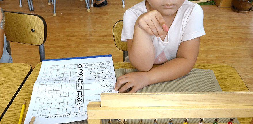 a child exploring size gradation with Montessori pink tower materials
