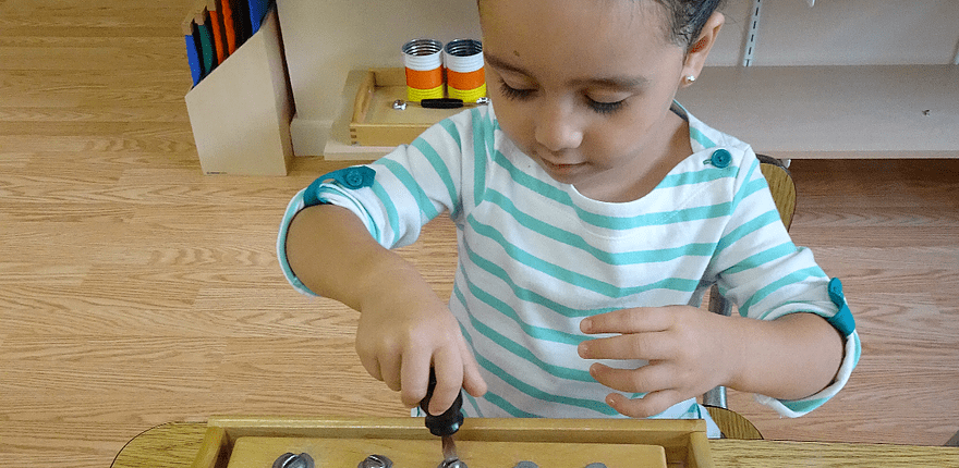 a child developing responsibility while cleaning up the Montessori classroom