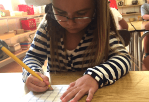 a child exploring geometric solids to learn about three-dimensional shapes