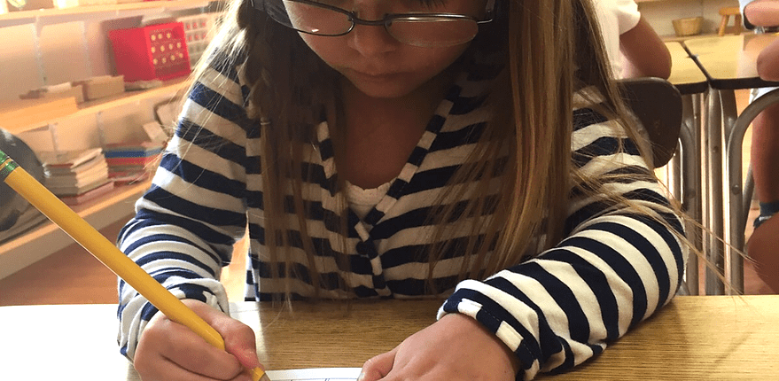 a child exploring geometric solids to learn about three-dimensional shapes