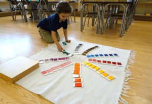 a child practicing phonics with Montessori movable alphabet and objects