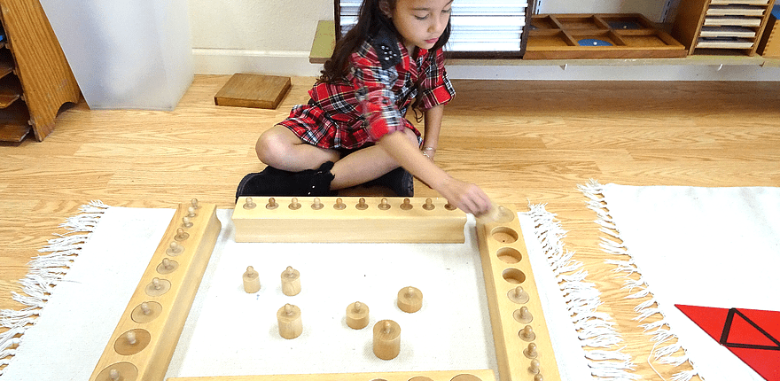 a child sequencing Montessori red rods to explore length and comparison