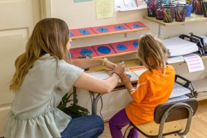 a child refining fine motor skills through bead stringing exercises